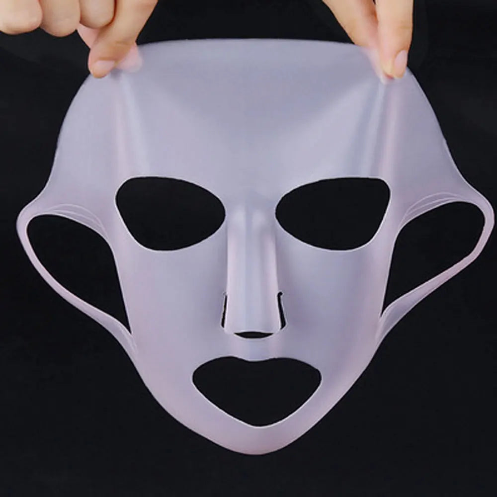 Clear silicone face mask held by hands against a black background