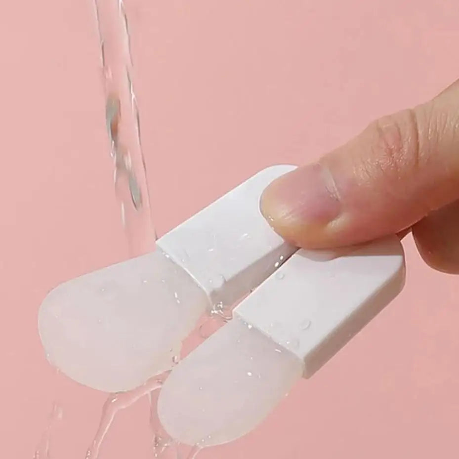 White silicone mold with a hand holding it against a pink background
