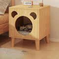 Wooden pet bed with cat inside on a wooden floor