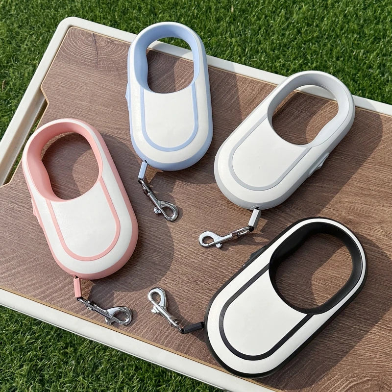 Four dog leashes with different color schemes on a wooden board outdoors.