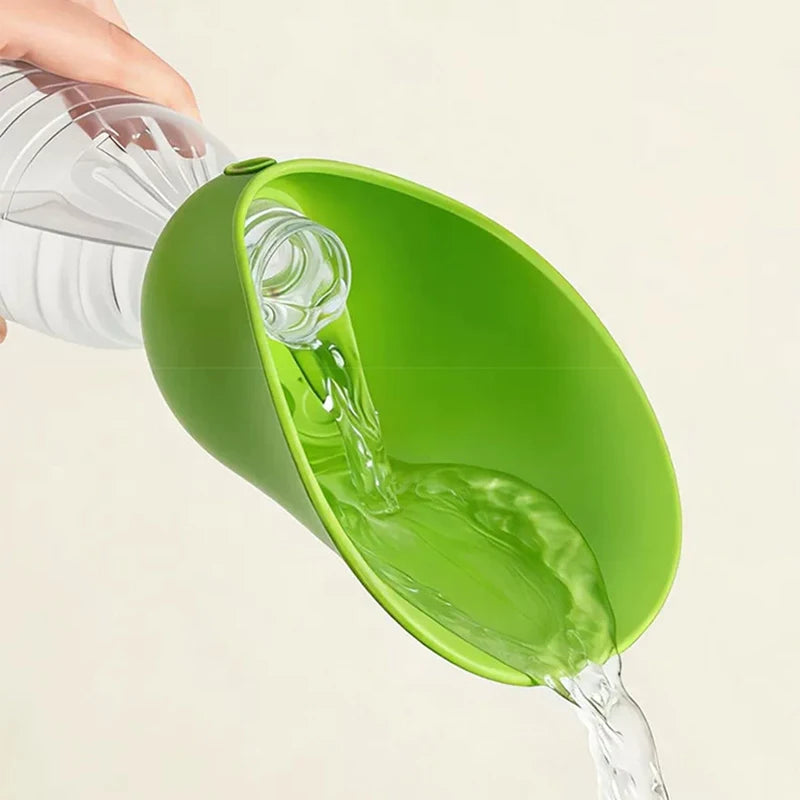 A bright green funnel-shaped bottle stopper held by a hand, shown pouring clear water from a plastic bottle into a container against a plain light background.