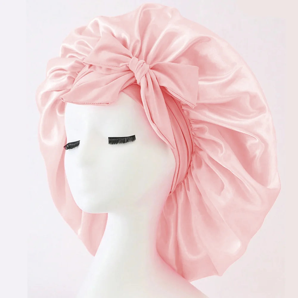 Pink satin head wrap on a mannequin head with a plain background