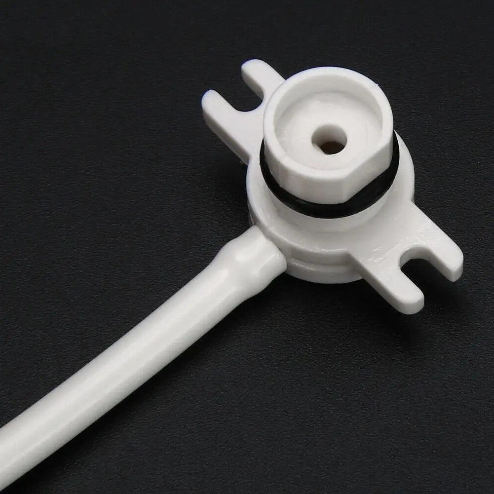 A white plastic mechanical or automotive part with a short stem and a forked mounting bracket, featuring a black rubber O-ring, shown on a dark textured background.