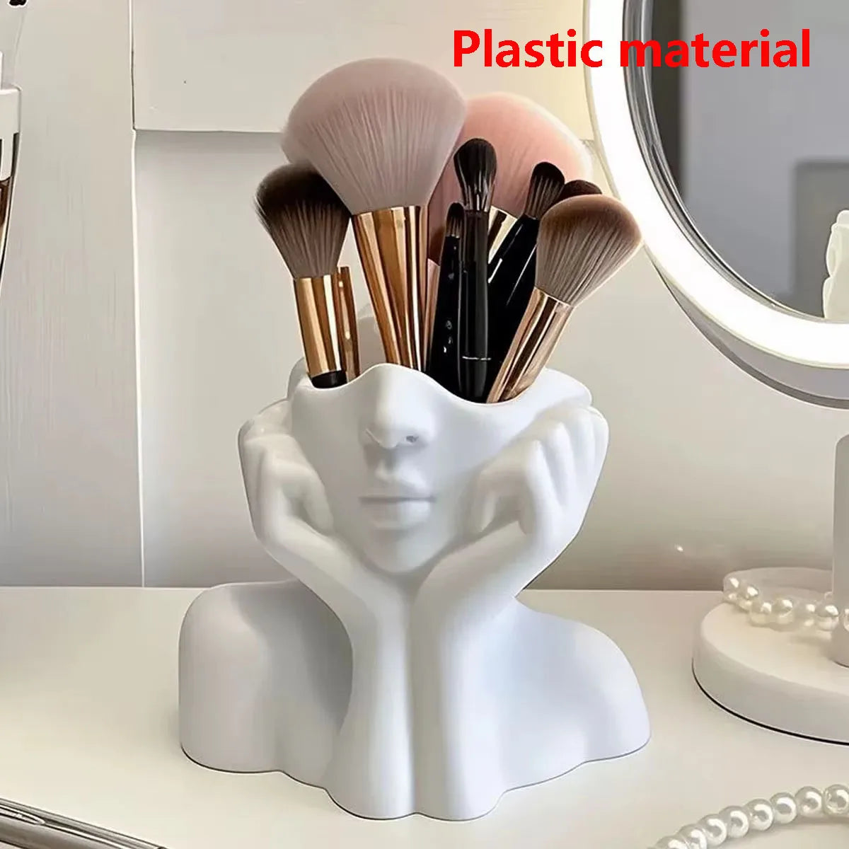 Makeup brush holder shaped like a face with makeup brushes on a vanity table.