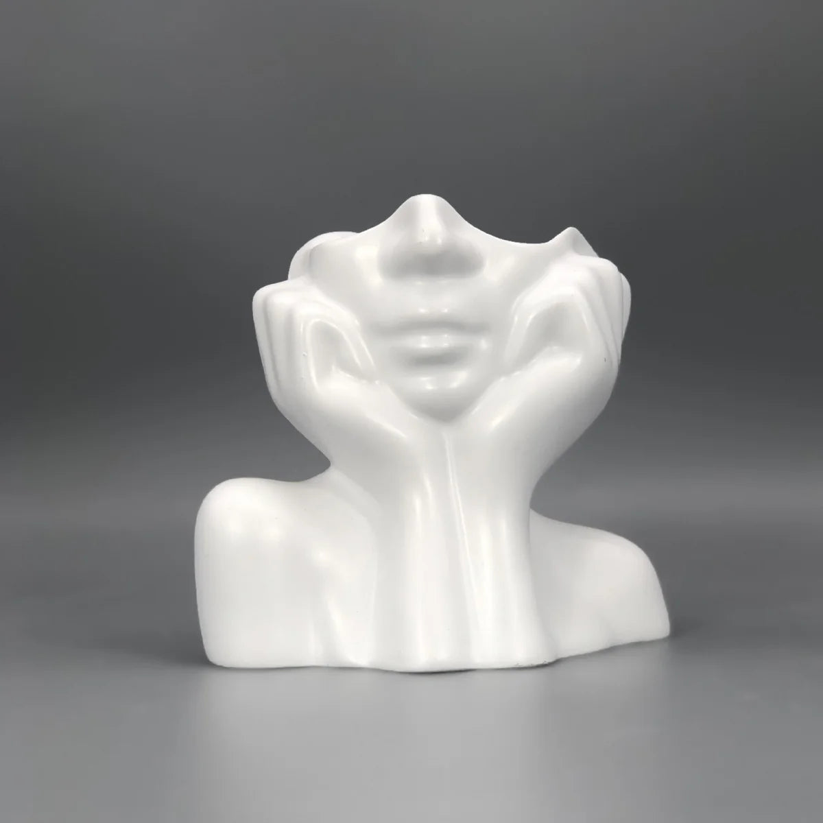 White ceramic bust sculpture on a gray background