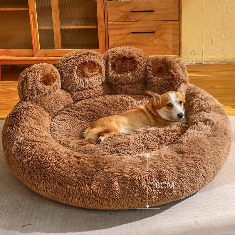 Dog lying on a fluffy brown pet bed in a room with wooden furniture.