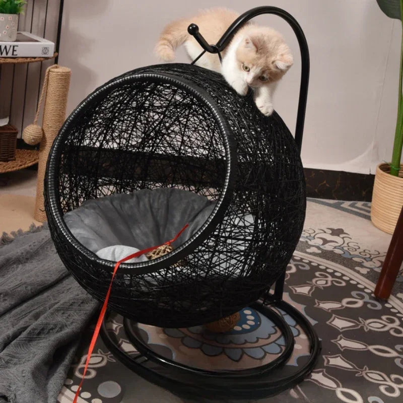 Black wicker cat swing with a cat inside on a patterned rug.