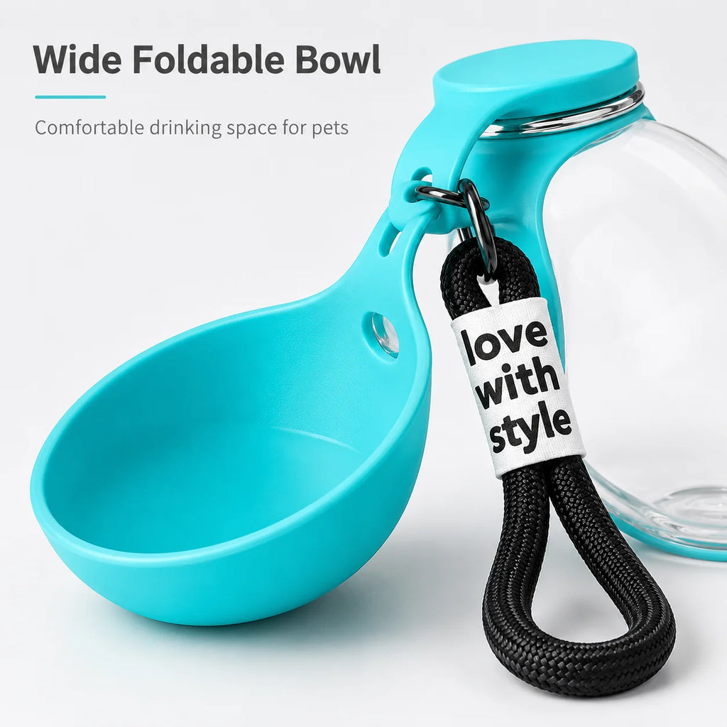 A turquoise wide-foldable pet bowl with a clear glass jar body, black carrying strap, and a white tag reading 'love with style'. Text at the top says 'Wide Foldable Bowl' and 'Comfortable drinking space for pets'.