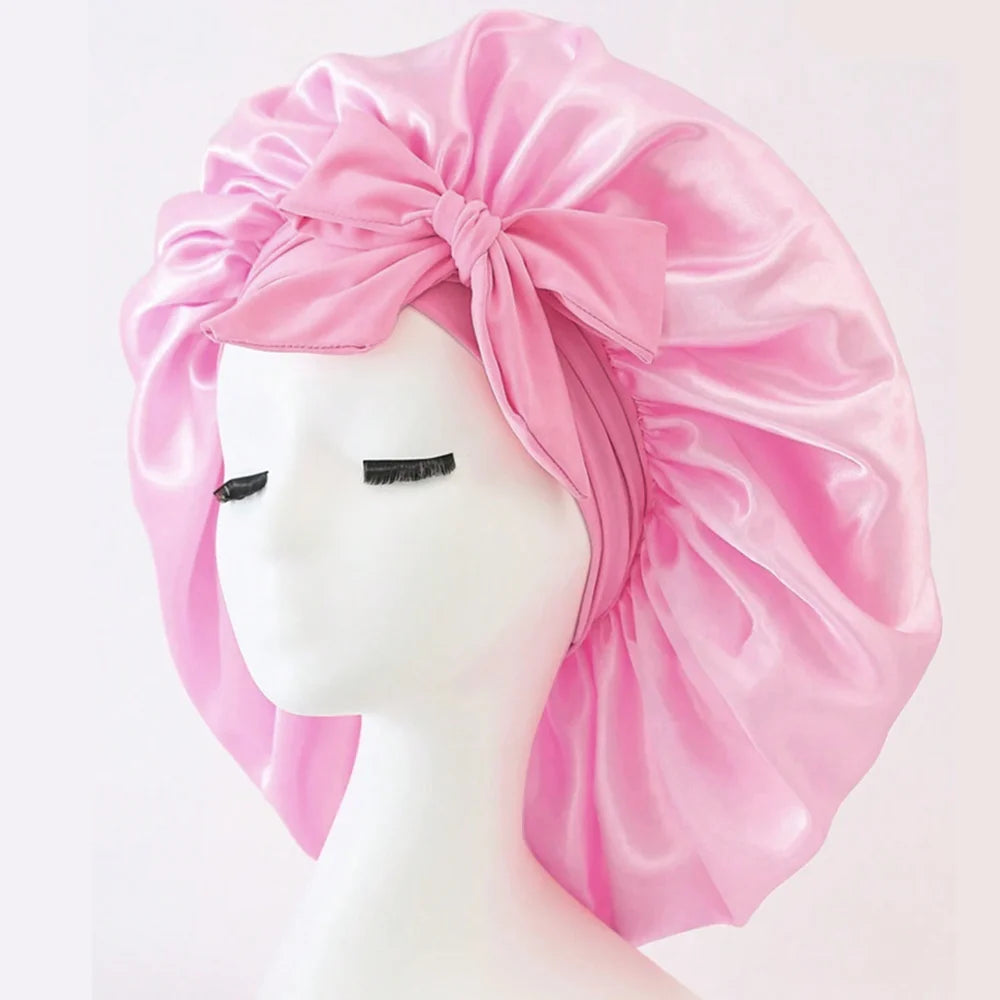 Pink satin head wrap on a mannequin head against a white background