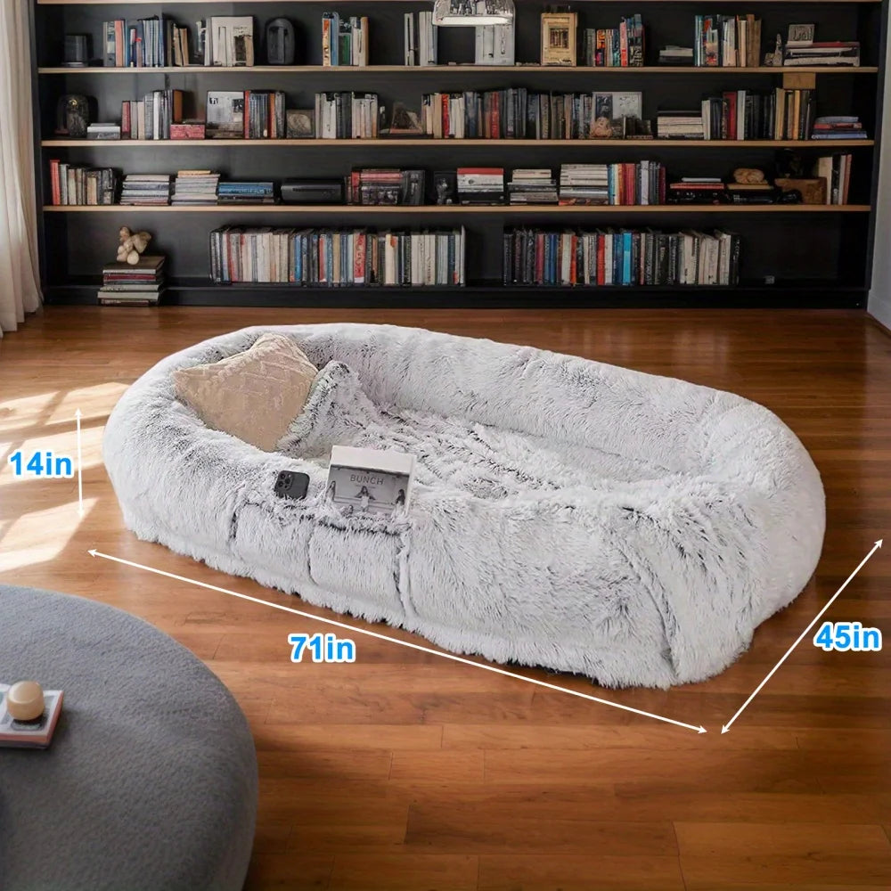 Fluffy pet bed with dimensions in a room with bookshelves.