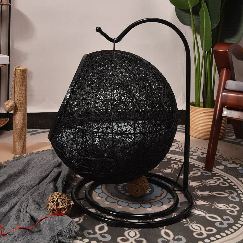 Black woven chair on a decorative rug with a plant and cat tree in the background