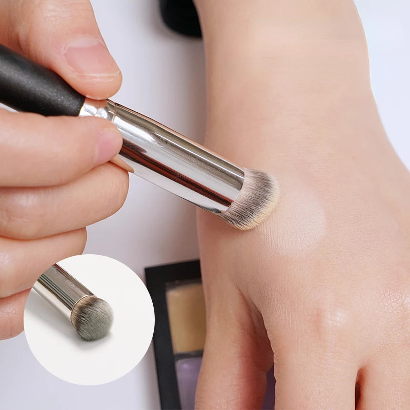 Makeup brush being used on a person's arm with close-up of brush tip.