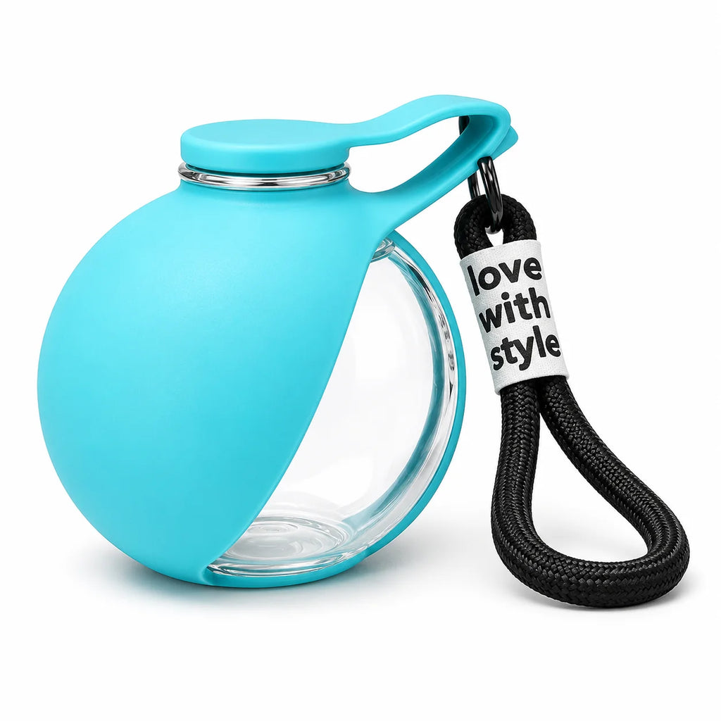A turquoise blue silicone sleeve protecting a clear glass water bottle, featuring a matching blue cap with a handle and a black braided carrying strap with a white tag that reads 'love with style'.