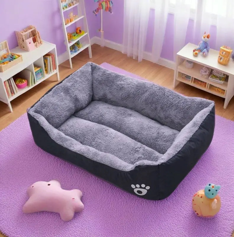 Gray pet bed on a purple rug in a room with toys and shelves.