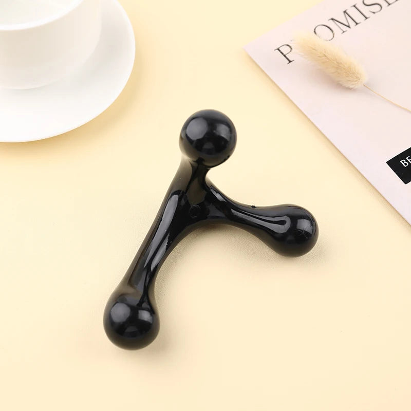 Black three-ball device on a beige surface with a blurred background