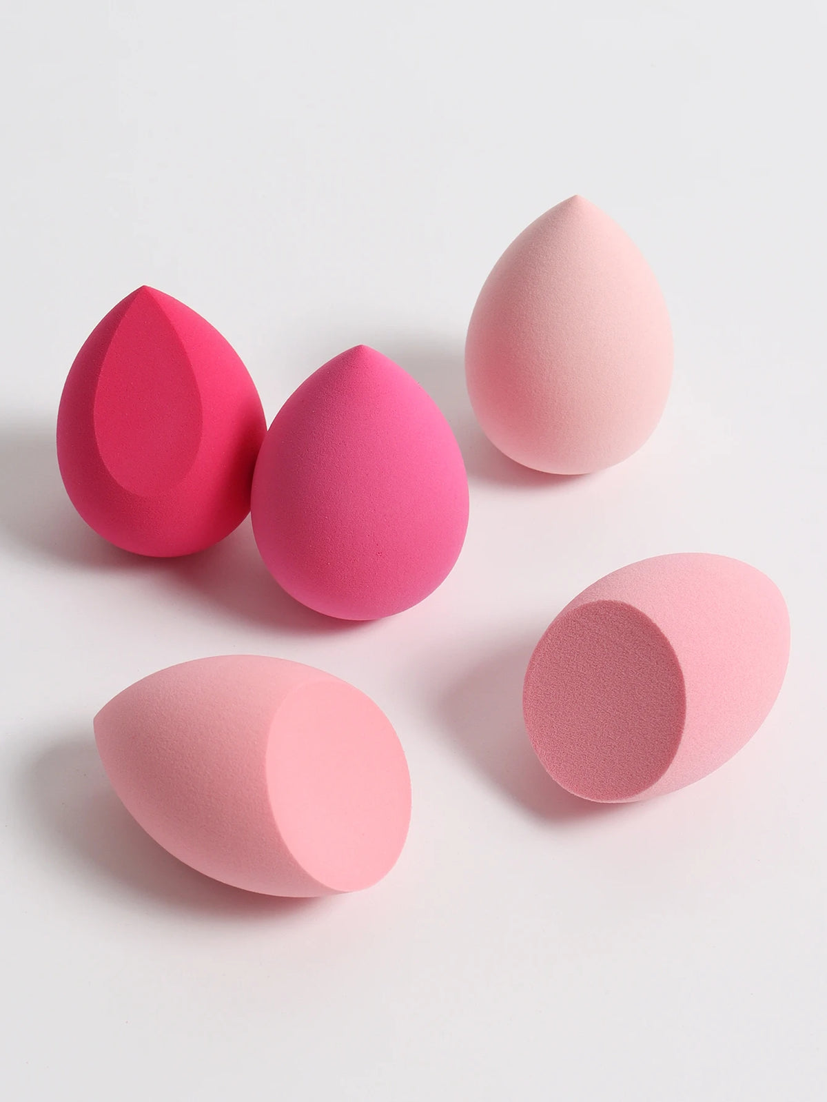 Set of pink makeup sponges on a light gray background