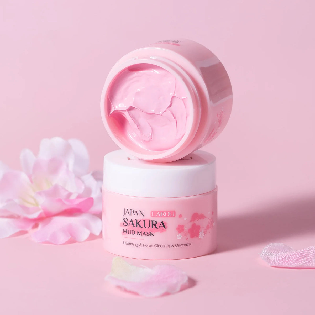 Pink mud mask jar with open lid on a pink background