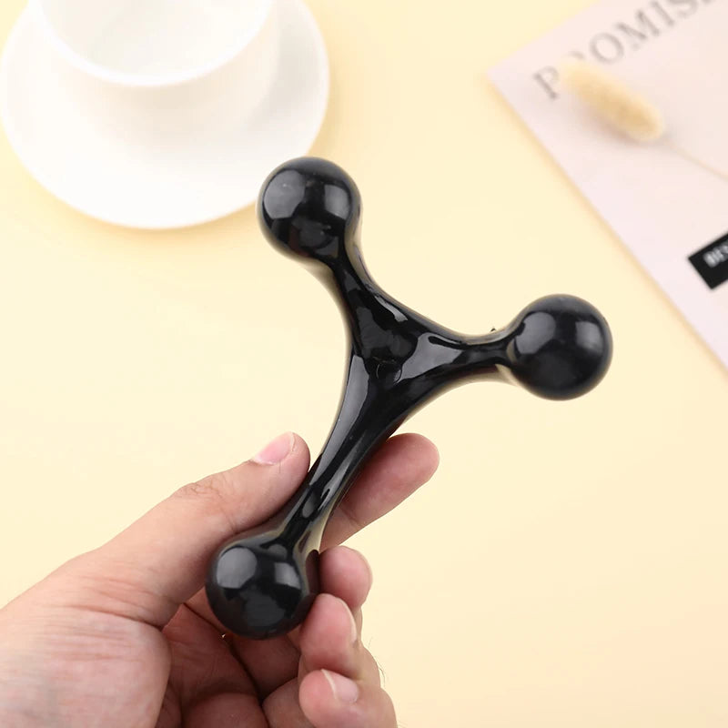 Black fidget spinner held in a hand with a light yellow background