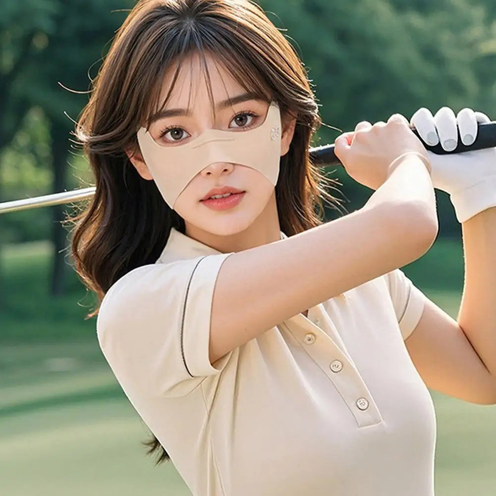 Woman in a beige shirt holding a golf club on a golf course