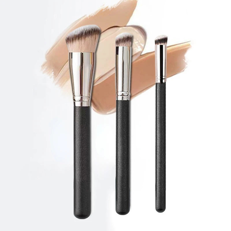 Three makeup brushes with black handles on a white background