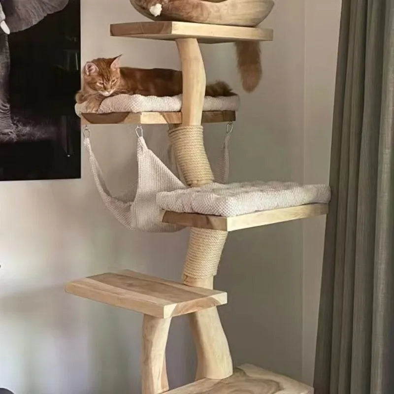 A tall wooden cat tree with multiple platforms, a hanging hammock, and sisal-wrapped scratching posts, shown in a room with a ginger cat resting on one of the upper platforms.