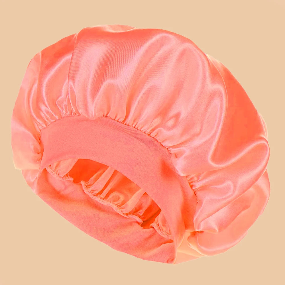 Pink satin hair bonnet on a beige background