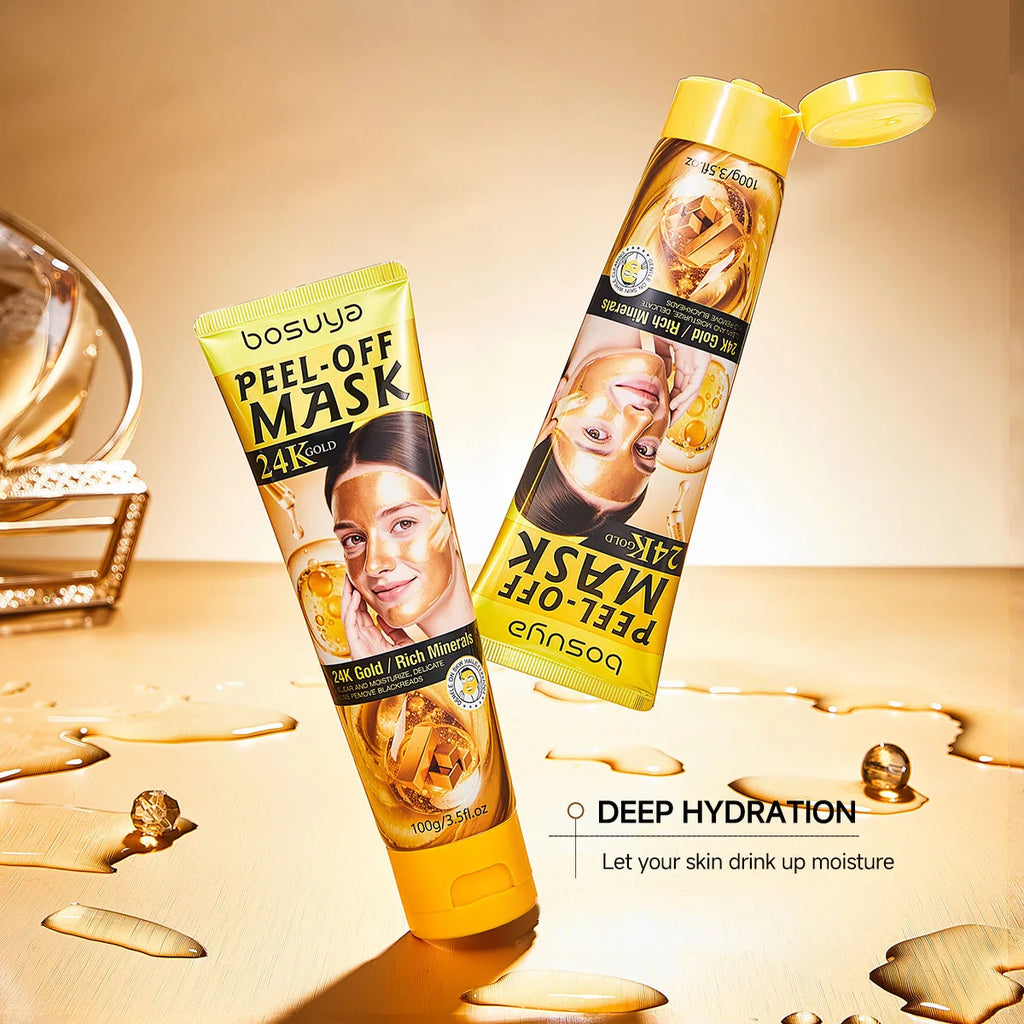 Two tubes of bosuya Peel-Off Mask 24K Gold shown on a warm beige surface with gold liquid and beads. One tube is upright and the other is tilted open, both featuring yellow caps and black/gold packaging with a face mask image.