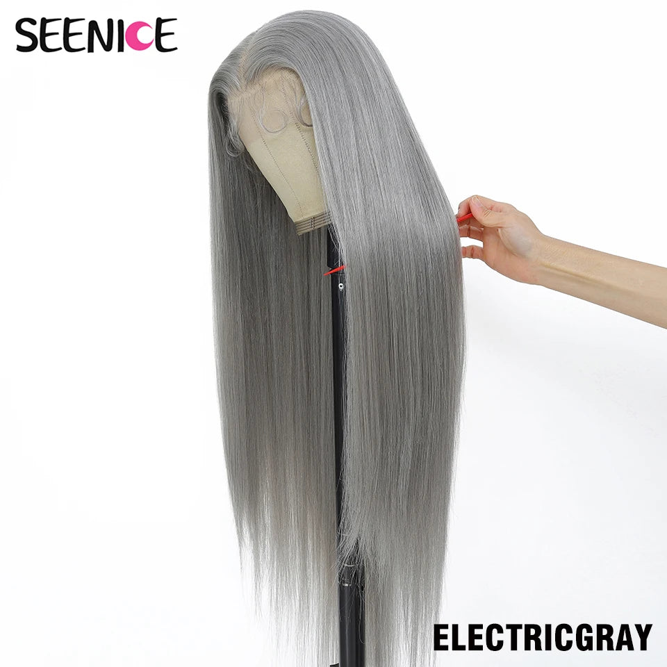 A long straight wig in a cool light gray shade displayed on a mannequin stand, with a hand holding the side hair to show the lace part and texture. The brand name 'SEENICE' is visible in the top left, and 'ELECTRICGRAY' is written in the bottom right.