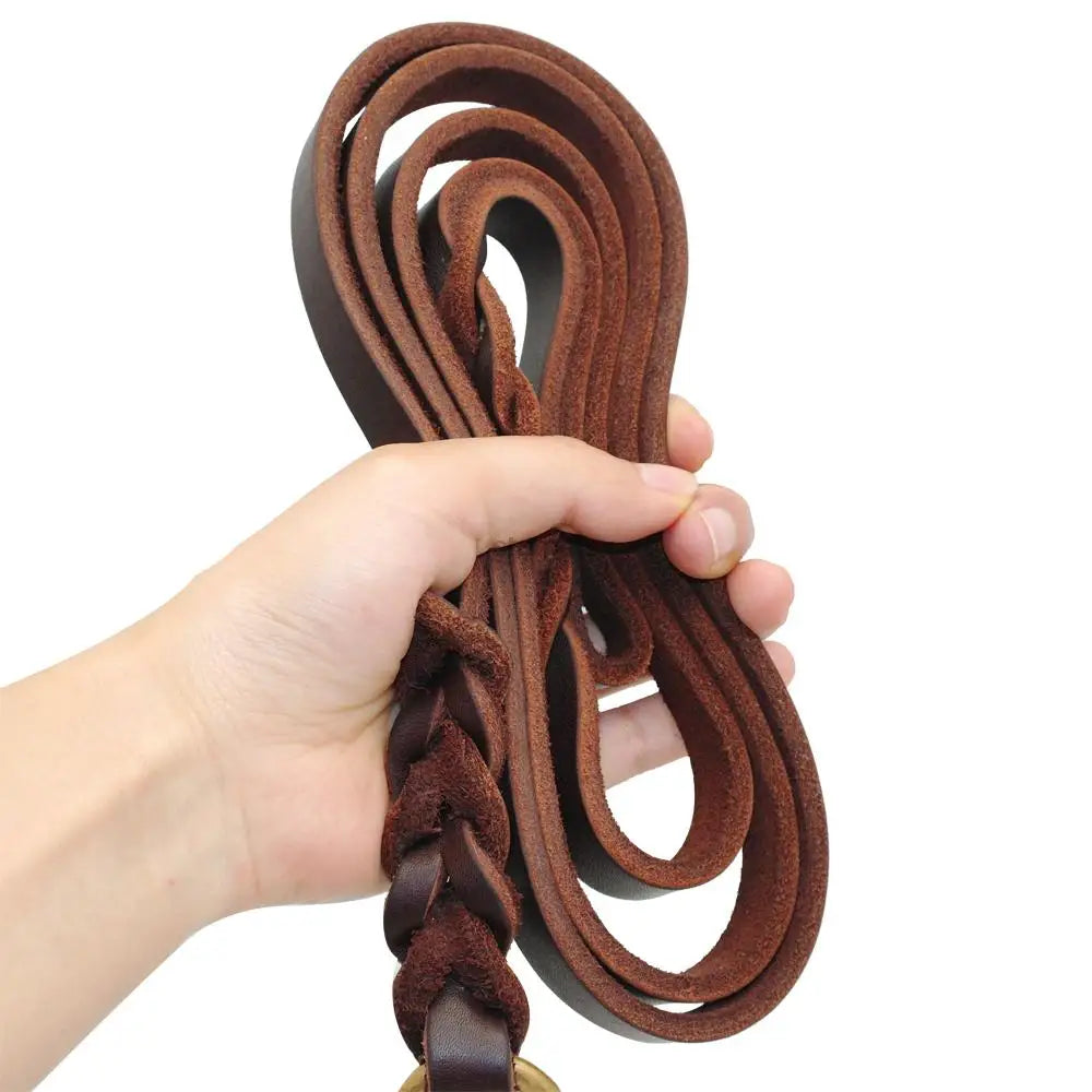 Hand holding a braided brown leather belt against a white background