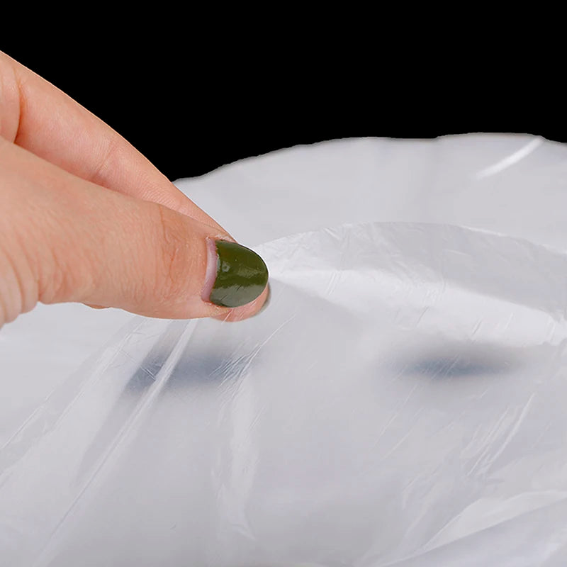 Hand holding a clear plastic bag with a black background