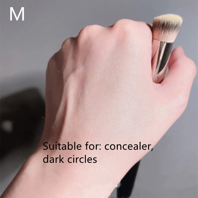 Hand holding a makeup brush with text indicating suitability for concealer and dark circles on a gray background.