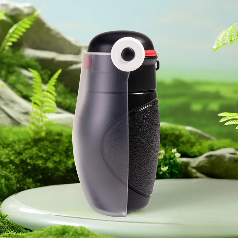 Black and gray spray bottle with a white nozzle against a green natural background