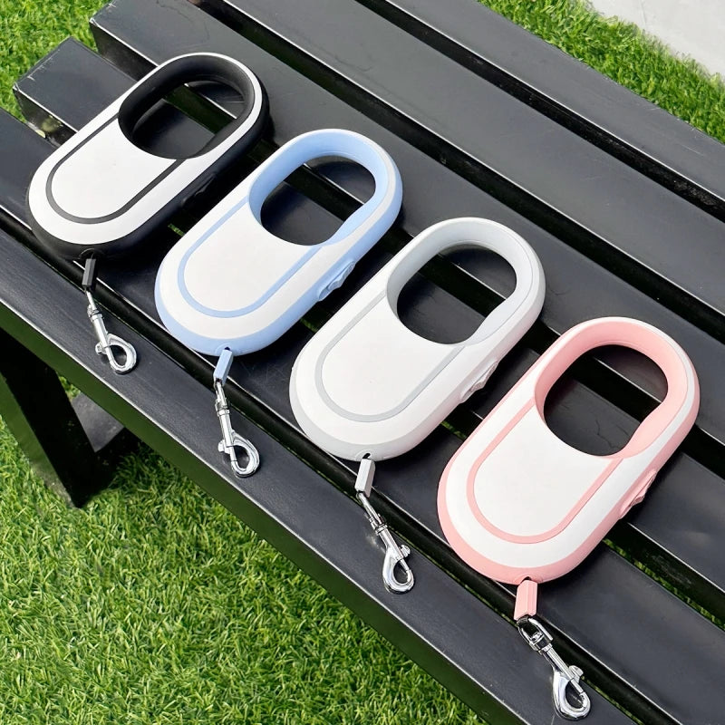 Four keychain cases in different colors on a black surface with grass in the background
