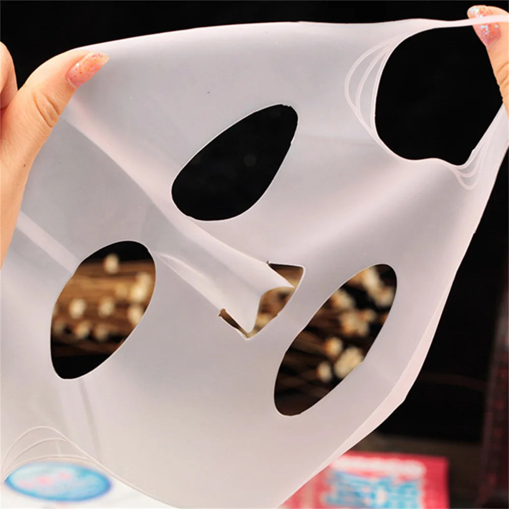 White silicone mask with cutouts held by hands against a blurred background