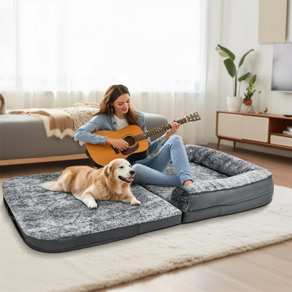 Woman playing guitar with a dog on a large pet bed in a living room.