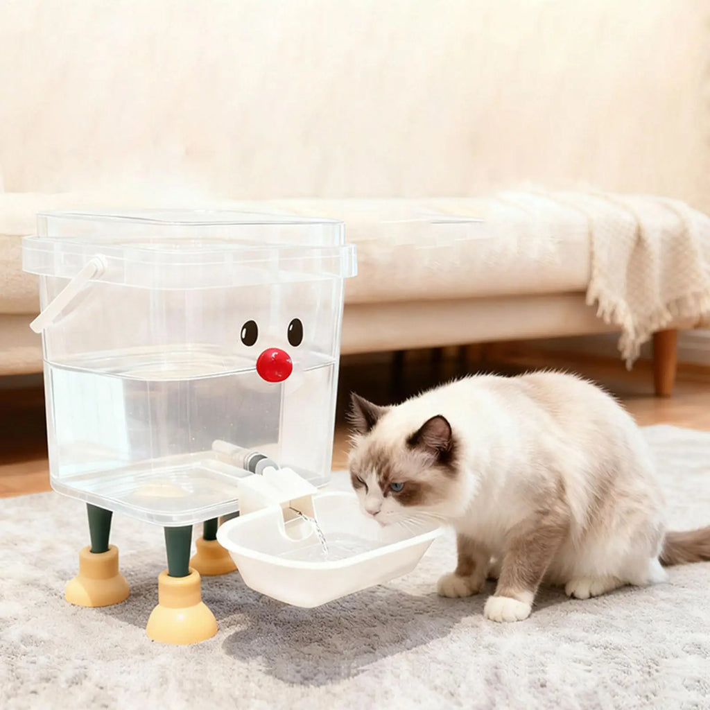Cat drinking water from a transparent pet fountain with a red nose on a carpeted floor.