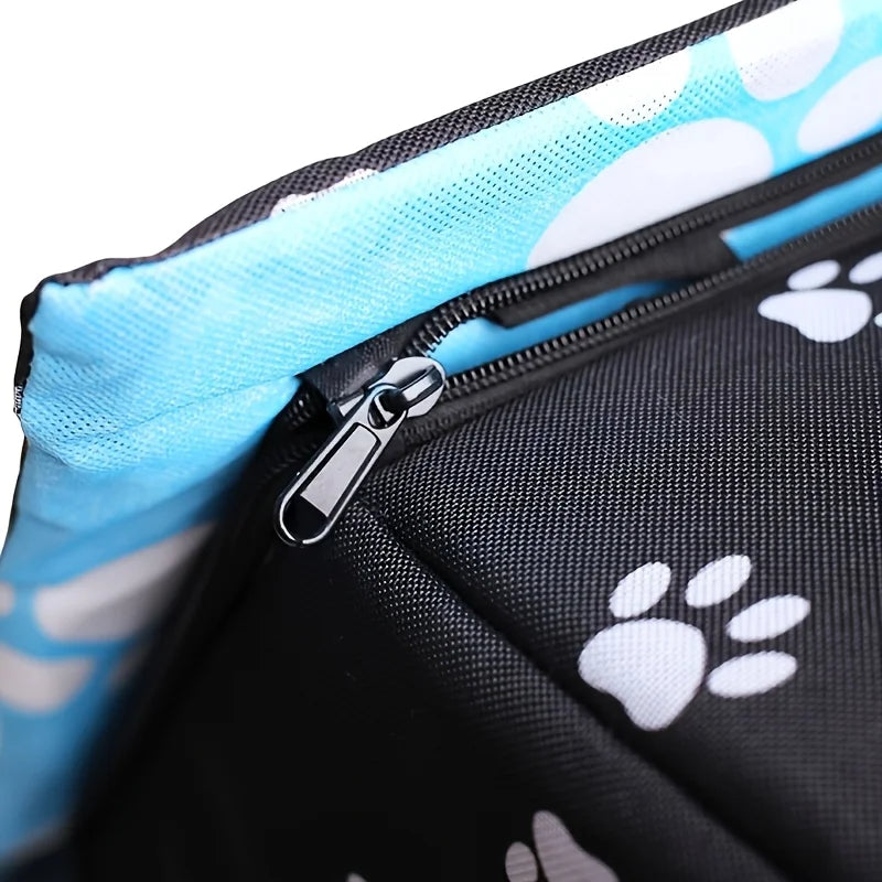 Close-up of a black zippered bag with white paw print patterns and a light blue mesh lining.