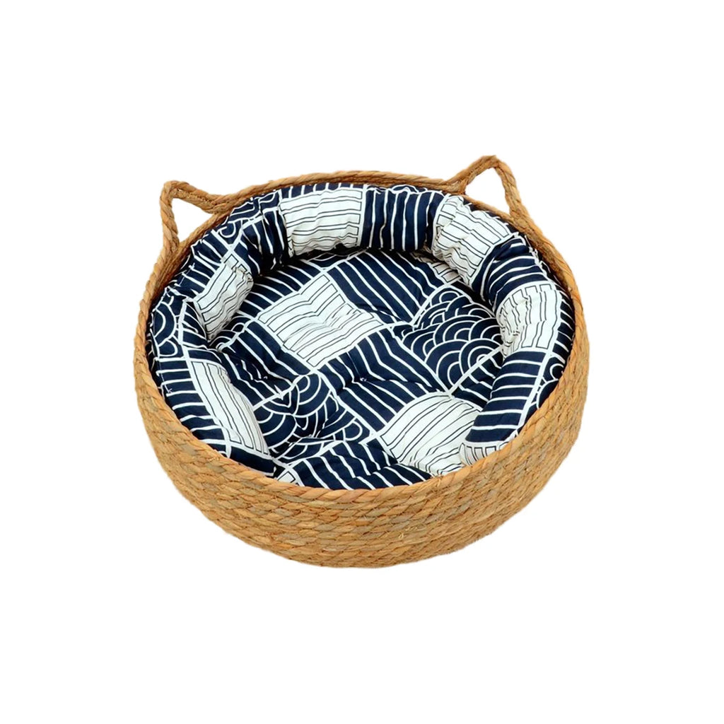 Woven pet bed with blue and white patterned cushion on a white background