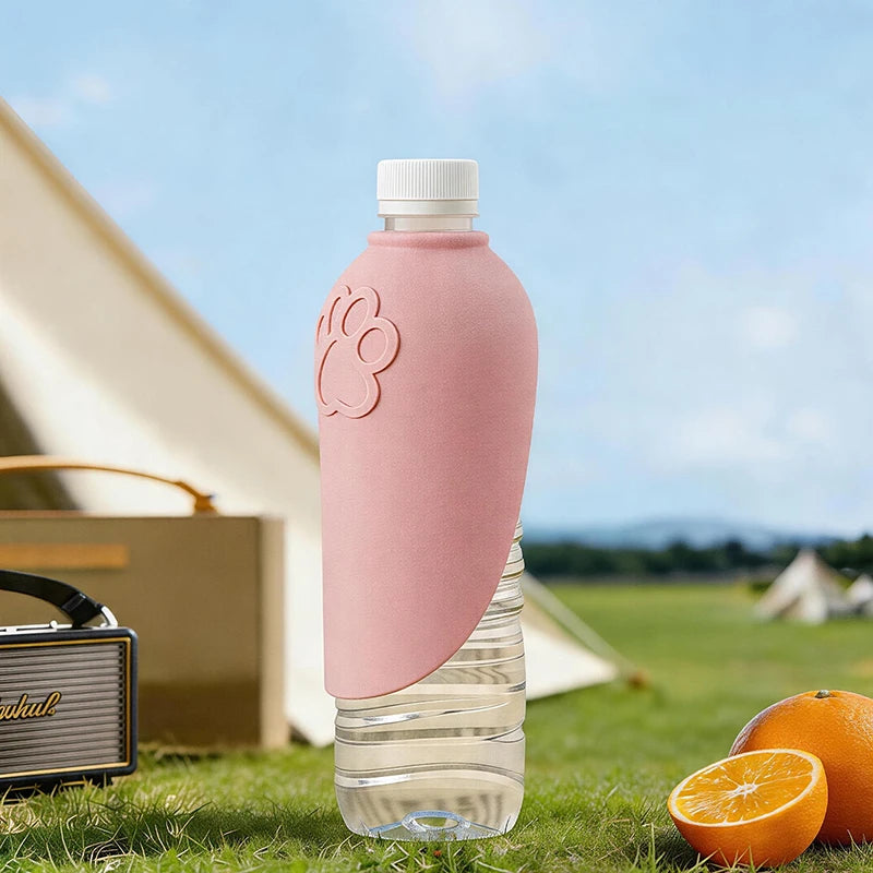 Pink water bottle with a paw print design outdoors, next to a tent and oranges.