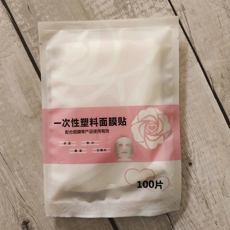 Pack of disposable plastic face mask sheets on a wooden surface