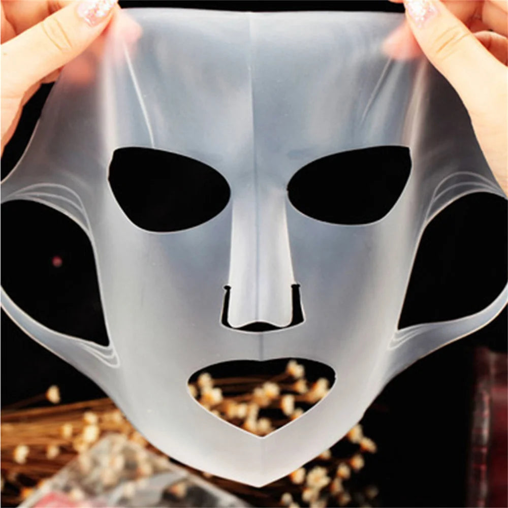 Transparent face mask with black accents held by hands against a dark background