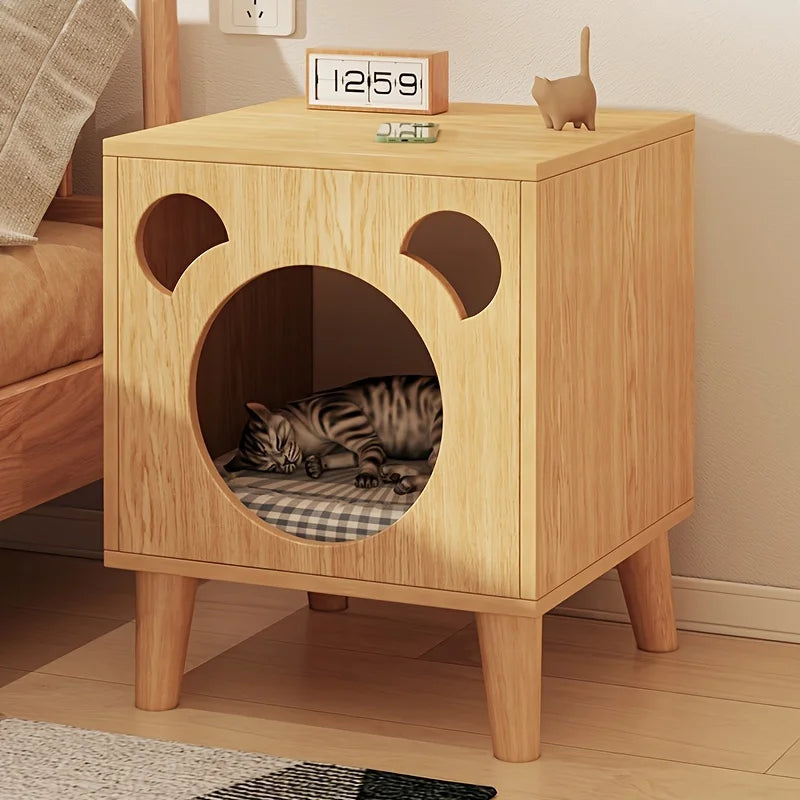 Wooden pet bed with cat inside, placed on a wooden side table.