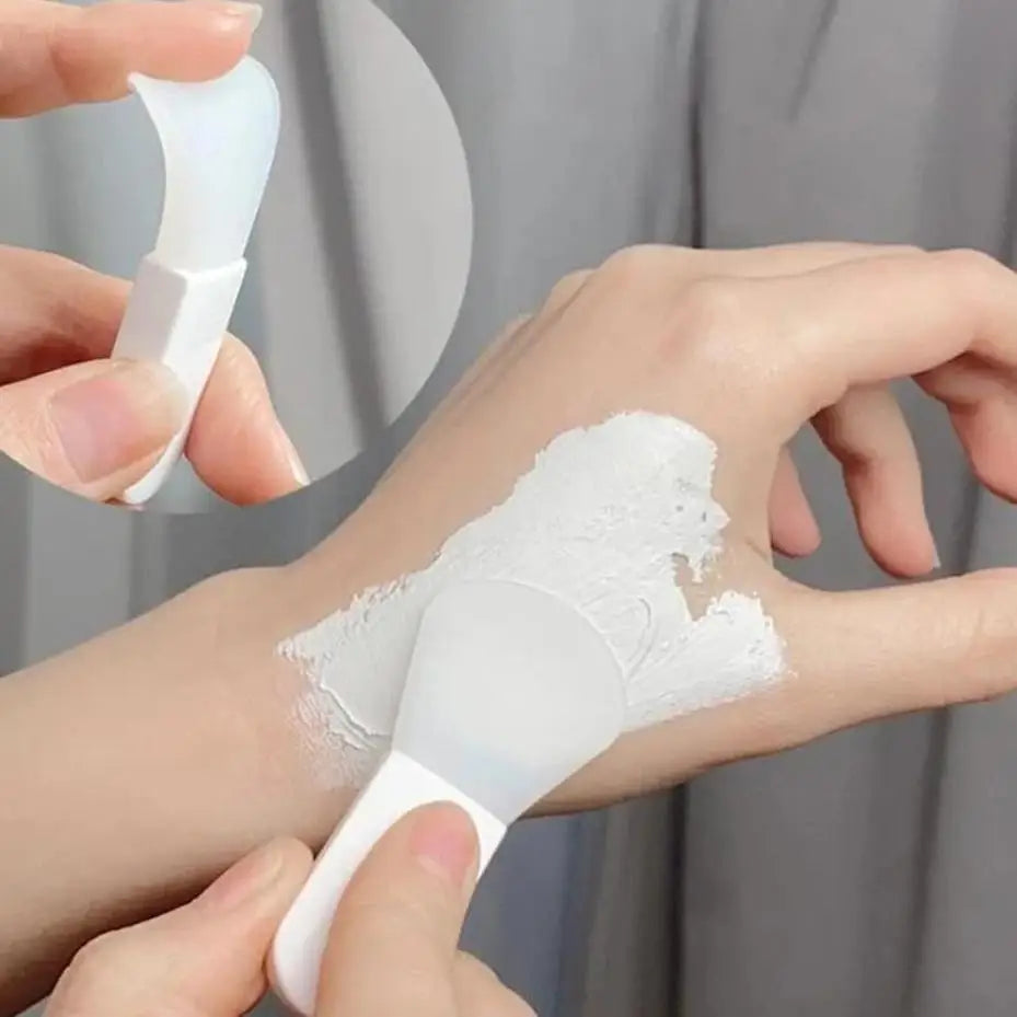 Person applying white cream to their wrist with a small applicator.