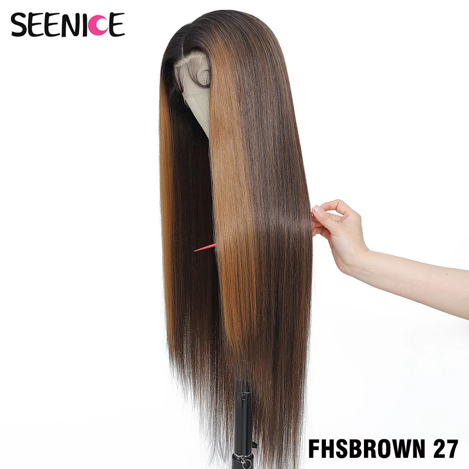 A long, straight wig with a dark brown root and warm caramel-brown highlights, displayed on a mannequin stand with a hand holding the hair to show its texture and weight. The brand logo 'SEENICE' is in the top-left corner, and the text 'FHSBROWN 27' is in the bottom-right.