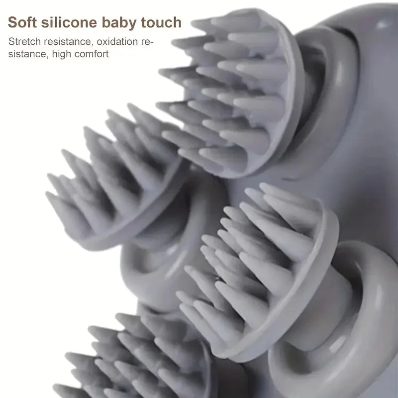 Close-up of a gray silicone baby massage or bath scrubber with multiple rounded nubs and circular attachment heads, shown against a white background with text reading 'Soft silicone baby touch' and additional descriptive copy.