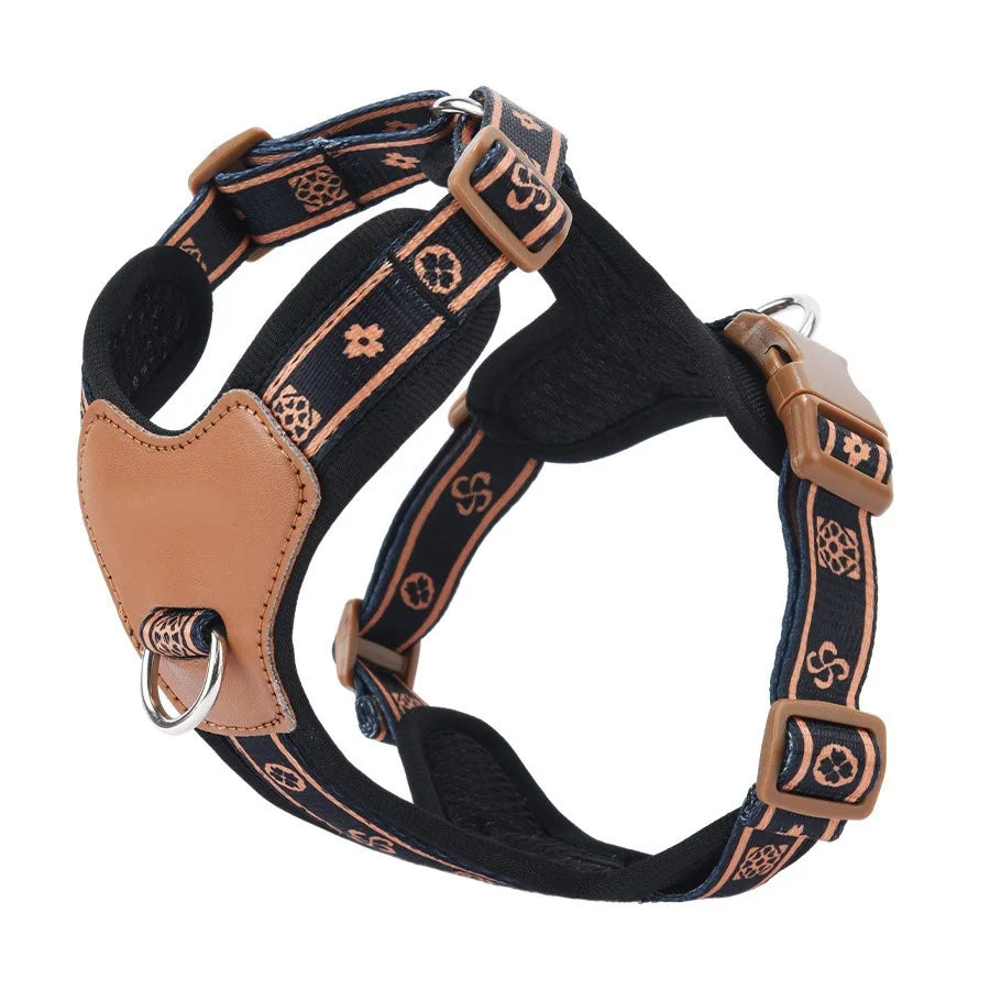 Dog harness with black strap and brown leather accents on a white background