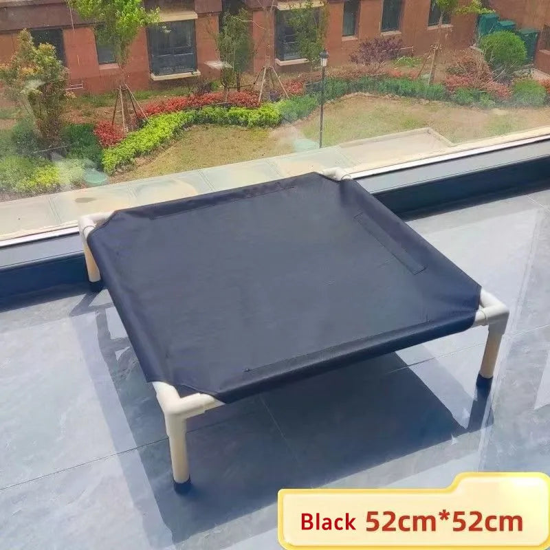 Black pet bed on a glass surface with a garden view outside