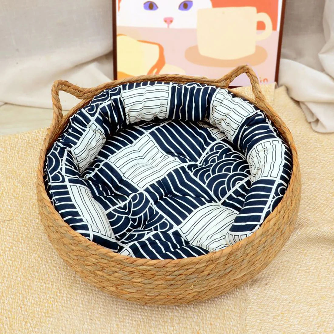 Woven pet bed with a blue and white patterned cushion on a beige surface.