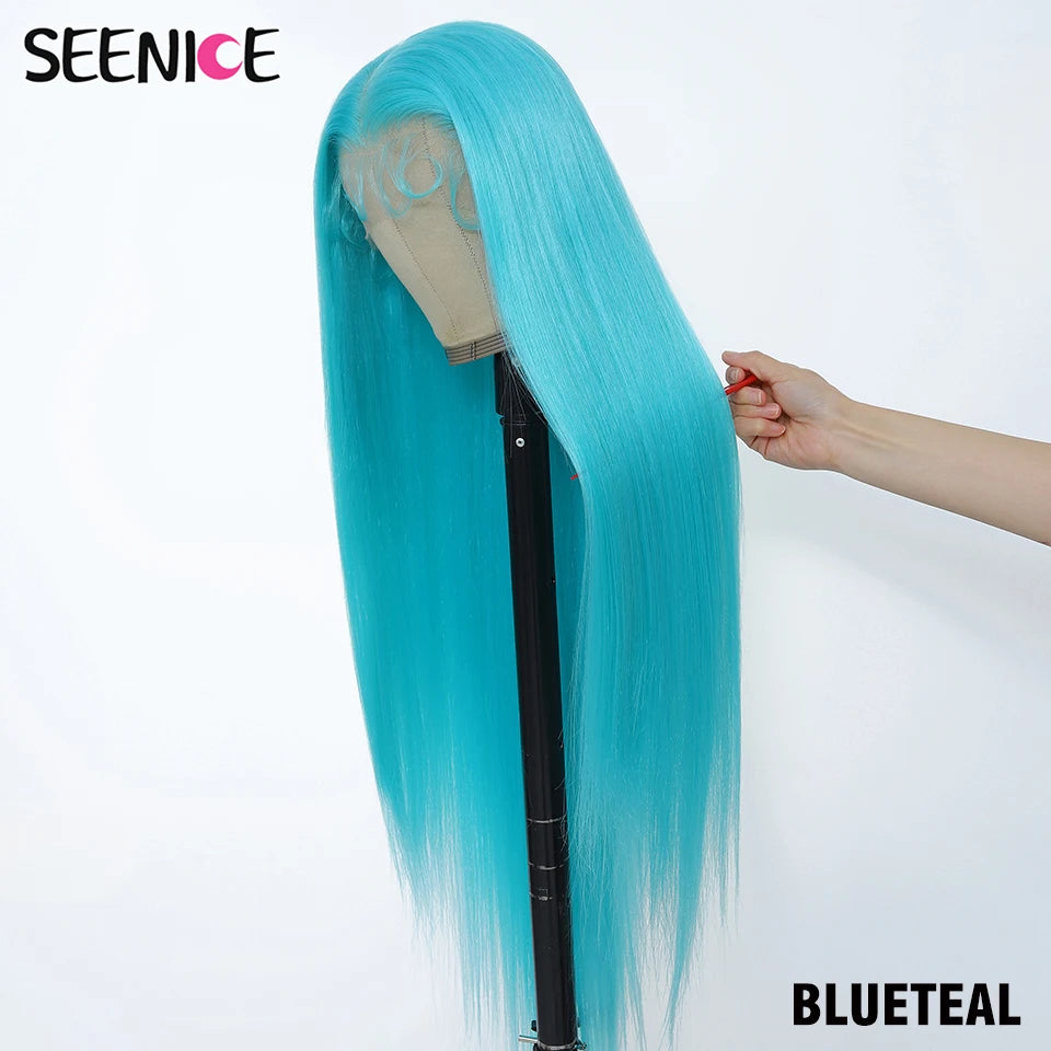A long, straight wig in a bright blue-teal shade displayed on a mannequin stand against a plain white background. A human hand is holding the side of the wig to show its texture and weight.