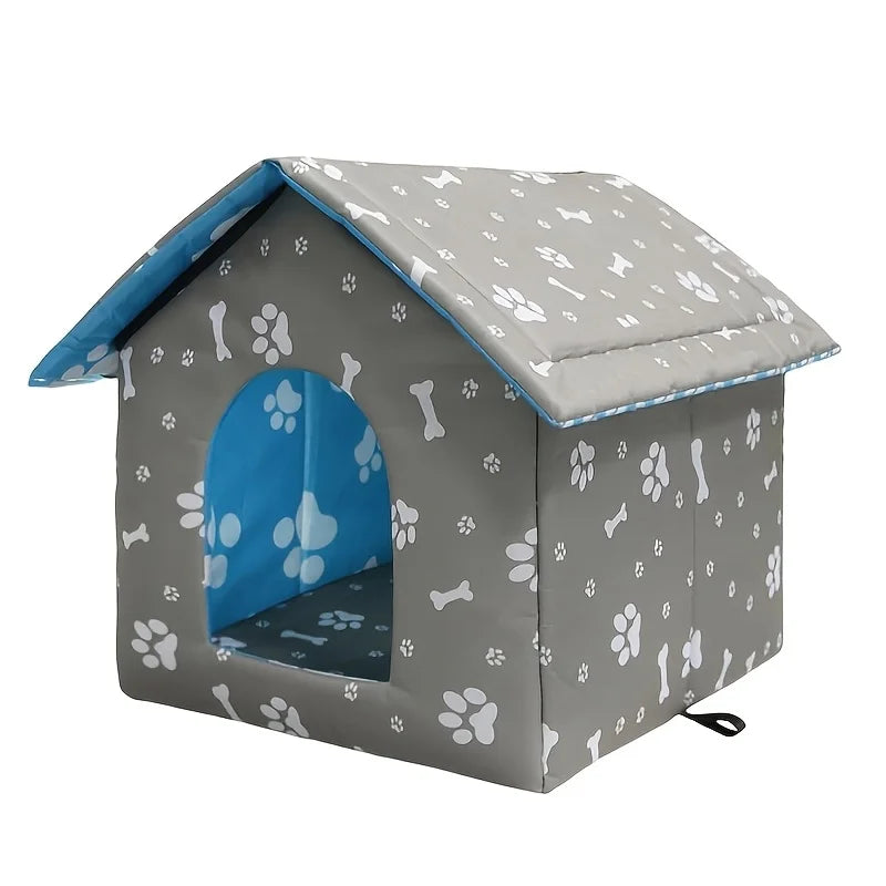 A gray fabric dog house with a white paw print and bone pattern, featuring a bright blue interior and a blue-trimmed roof, shown on a plain white background.